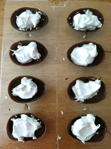 STEP 3: Take the molds out of the freezer and put about a teaspoon of creme filling in each chocolate shell.